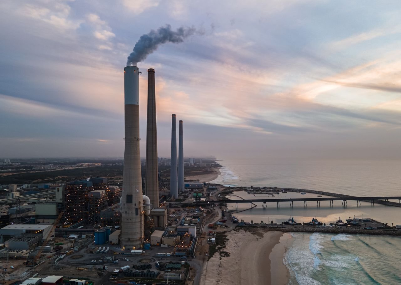 Crafting Captivating Headlines: Your awesome post title goes here Aerial view of an industrial plant by the ocean with smoke stacks at sunset, capturing an industrial and serene contrast.